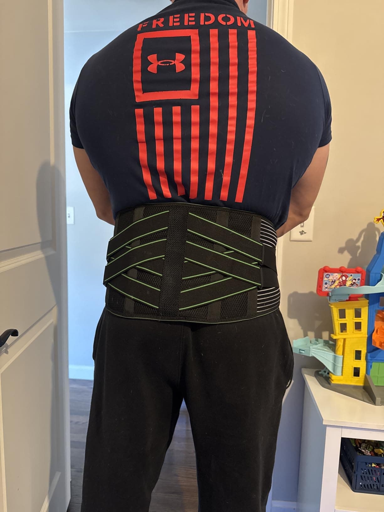 Customer wearing the Bracelite lumbar support showing the X-cross support structure across the lower back